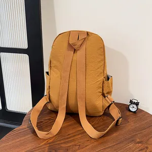 Vista dettagliata dello schienale di uno zaino in nylon giallo senape con spallacci ampi