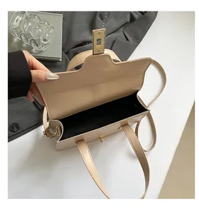 Detailed top view of beige faux leather handbag showing metal clasp and inner compartment