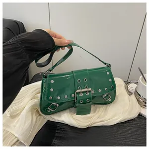 Dettaglio della borsa a spalla in pelle verniciata verde scuro con rivetti e fibbia in metallo
