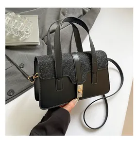 Detail of black crossbody bag featuring sequin panels and a gold twist lock closure
