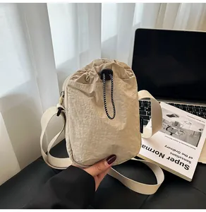 Macro shot of beige waterproof nylon crossbody bag with drawstring closure and soft texture
