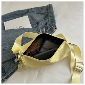 Bovenaanzicht gele cilindrische crossbodytas met interne opbergruimte voor een telefoon