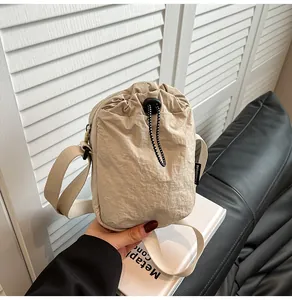 Detail of waterproof nylon crossbody bag with drawstring closure and fashion tag