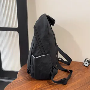 Vista laterale dello zaino nero in nylon con tasca laterale funzionale e fibbia regolabile