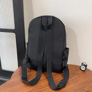 Dettaglio degli spallacci e delle tasche laterali di uno zaino in nylon nero casual