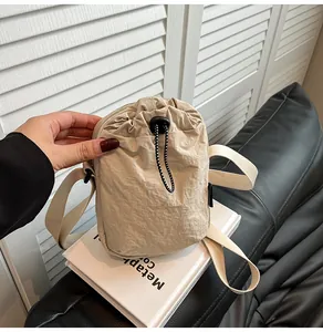 Detail of waterproof nylon crossbody bag with drawstring closure and adjustable strap