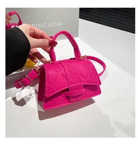 Detailed view of magenta felt crossbody bag with quilted stitching and handle