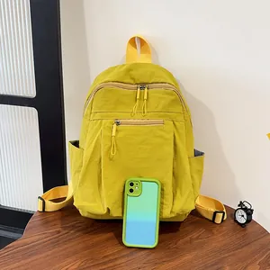 Dettaglio di uno zaino in nylon giallo brillante accanto a uno smartphone per la misura