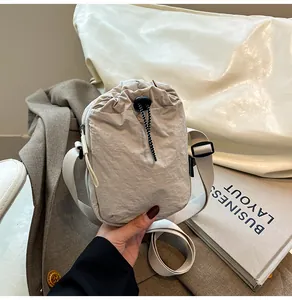 Detail view of the drawstring closure on a lightweight nylon waterproof crossbody bag