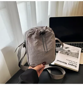 Macro view of grey waterproof nylon crossbody bag with drawstring pocket detail