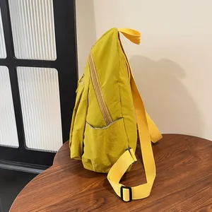 Dettaglio dello zaino in nylon giallo con tasca laterale e tracolla regolabile