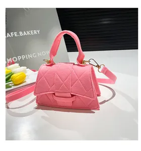 Detailed macro view of pink felt crossbody bag with quilted diamond pattern and gold metal hardware