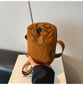 Detail of waterproof nylon crossbody bag with drawstring pocket and fashion woven label