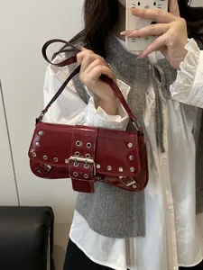 Borsa a spalla in pelle verniciata rossa con fibbia metallica e borchie in stile Y2K