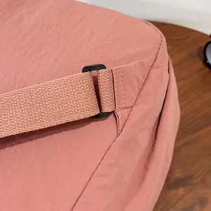 Dettaglio cuciture rinforzate e fibbia nera su zaino da viaggio in nylon rosa