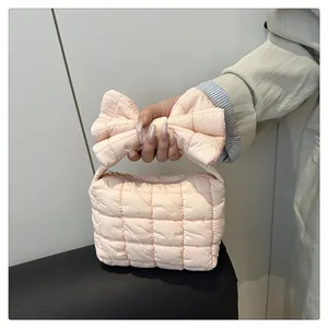 Dettaglio borsa a nuvola trapuntata rosa con grande manico a fiocco e zip metallica