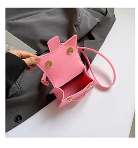Detail view of pink felt mini bag with magnetic gold clasps and soft fiber texture