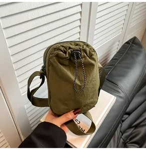 Army green nylon mini crossbody bag with drawstring closure and shoulder strap