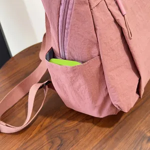 Vista dettaglio della tasca laterale dello zaino in nylon rosa con trama plissettata