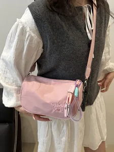 Roze crossbody tas met borduursel, kussenvorm en een stijlvolle geweven hanger