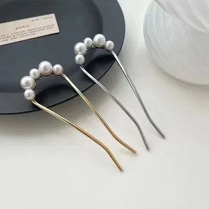 Detail of U-shaped hair pin with gradient white pearls on gold and silver metal