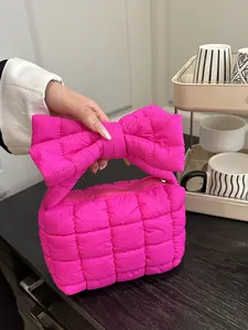 Borsa a mano trapuntata rosa acceso con grande manico a fiocco in tessuto a pieghe