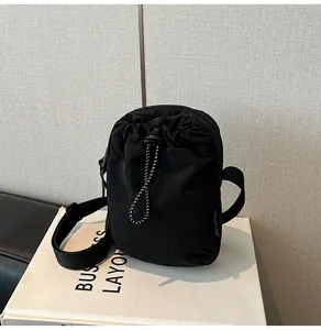 Detail of waterproof nylon crossbody bag with drawstring closure and metal zipper