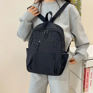 Zaino in nylon nero impermeabile per viaggi casual indossato da una modella in interno