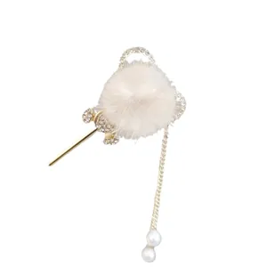 Cute white pom-pom hair pin with rhinestones and pearl chain for winter hairstyles