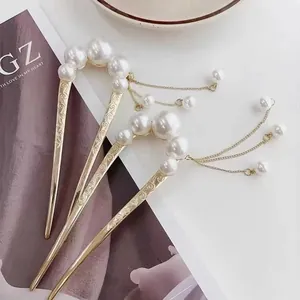 Elegant gold U-shaped hairpins with white pearls and long tassels in a minimalist style