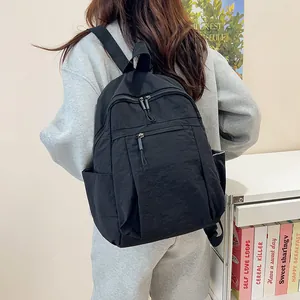 Dettaglio dello zaino nero in nylon capiente con multitasche e portabottiglie laterali