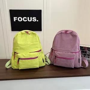 Detail view of fluorescent green and dark purple nylon backpacks with pink contrast zippers
