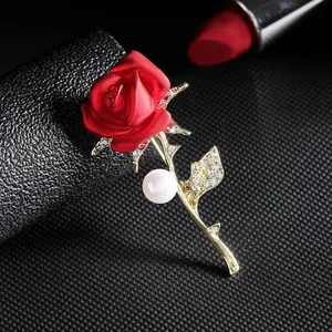 Elegant red rose brooch with gold leaves, rhinestones and pearl on black display