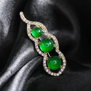 Broche élégante en forme de cosse de pois avec pierres vertes et cristaux sur soie