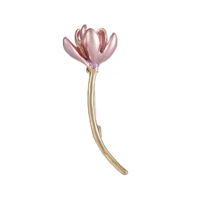 Elegant lotus brooch with pink pearlescent enamel and gold stem on white background