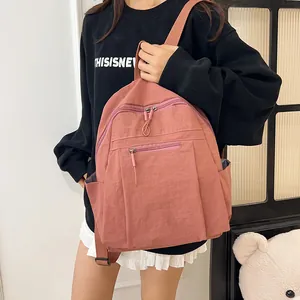 Dettaglio di uno zaino in nylon rosa con spallacci regolabili e tasche multiple