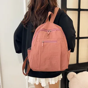 Dettaglio dello zaino in nylon rosa antico con ampi scomparti e tasche laterali capienti