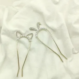 Detail of U-shaped hair pins with gold plating, white pearls and sparkling rhinestones