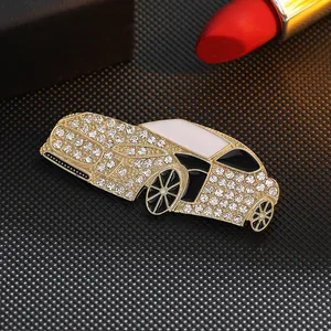 Golden car brooch with sparkling rhinestones and enamel finish on black display