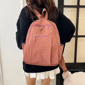 Dettaglio dello zaino in nylon rosa impermeabile indossato da una modella casual