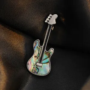 Artistic guitar brooch with colorful shell inlay and crystal accents on black silk