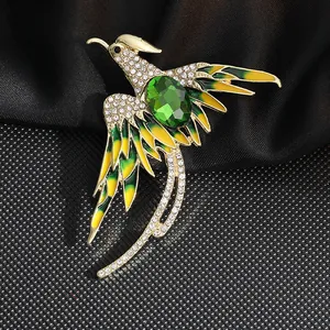 Detalle del broche de fénix con piedra esmeralda verde y esmalte colorido retro