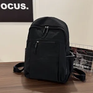 Dettaglio dello zaino in nylon nero con doppia zip e tasche laterali in stile casual