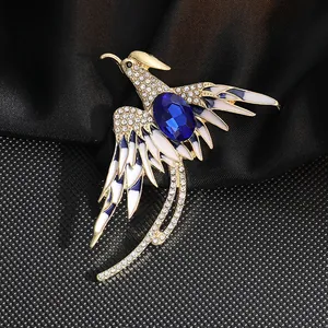 Detalle de broche de fénix elegante con cristal azul y pedrería sobre fondo de seda negra