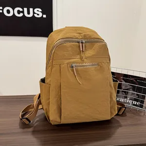 Dettaglio dello zaino in nylon giallo zenzero impermeabile con tasche su legno