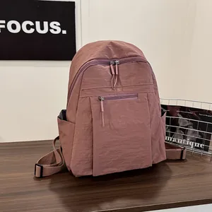 Dettaglio dello zaino in nylon rosa antico con tasca frontale a zip e tasche laterali