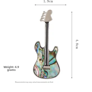 Detail view of electric guitar brooch with iridescent shell inlay and crystal accents