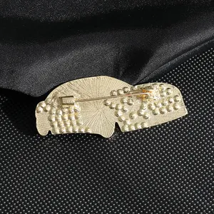 Back view of gold sports car brooch with rhinestone inlay and safety pin closure