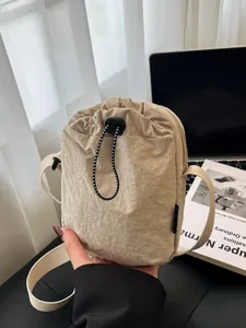 Waterproof beige nylon crossbody bag with drawstring pocket for outdoor leisure activities