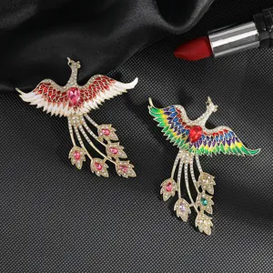 Detalle de elegantes broches de fénix con esmalte colorido y pedrería brillante